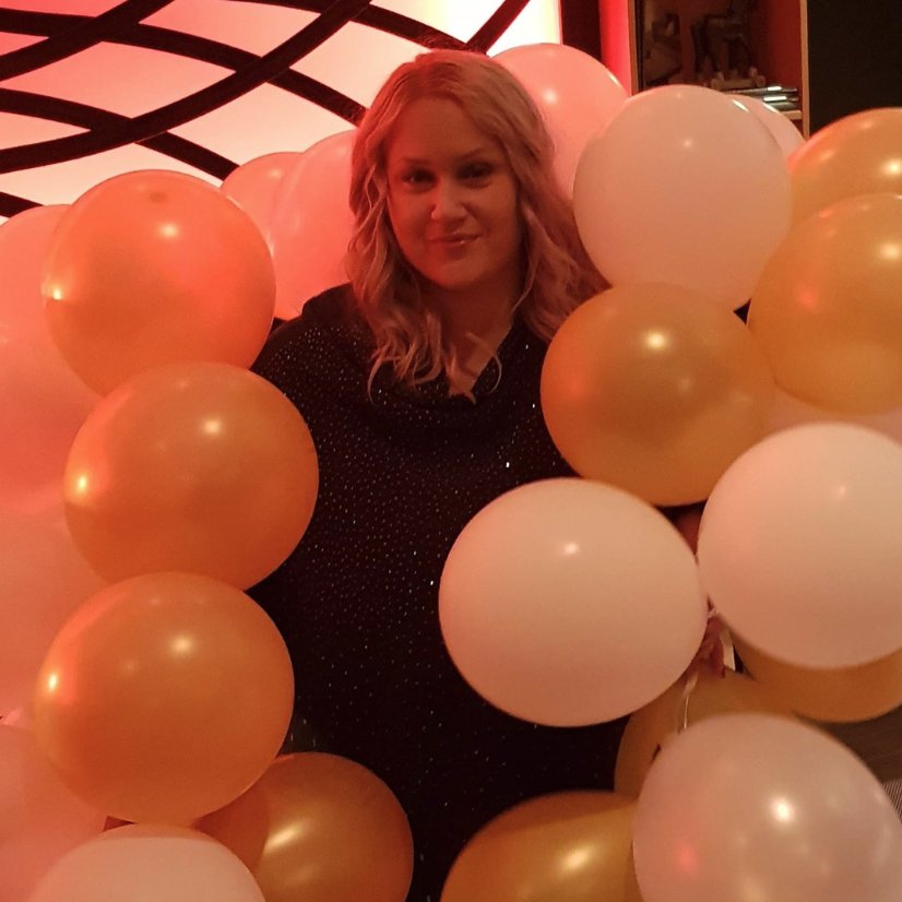 Bild på Mia omringad i ett hav av ballonger